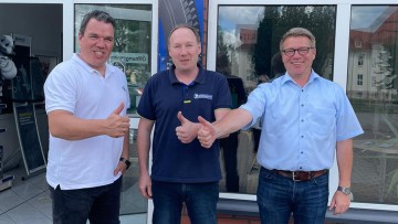 Stephan Duvigneau (Euromaster), Lutz Lindenberg (Geschäftsführer Reifen & Auto Service Lindenberg) und Bernd Franzen (Euromaster) bei der Vertragsverlängerung von Reifen & Auto Service Lindenberg in Staßfurt